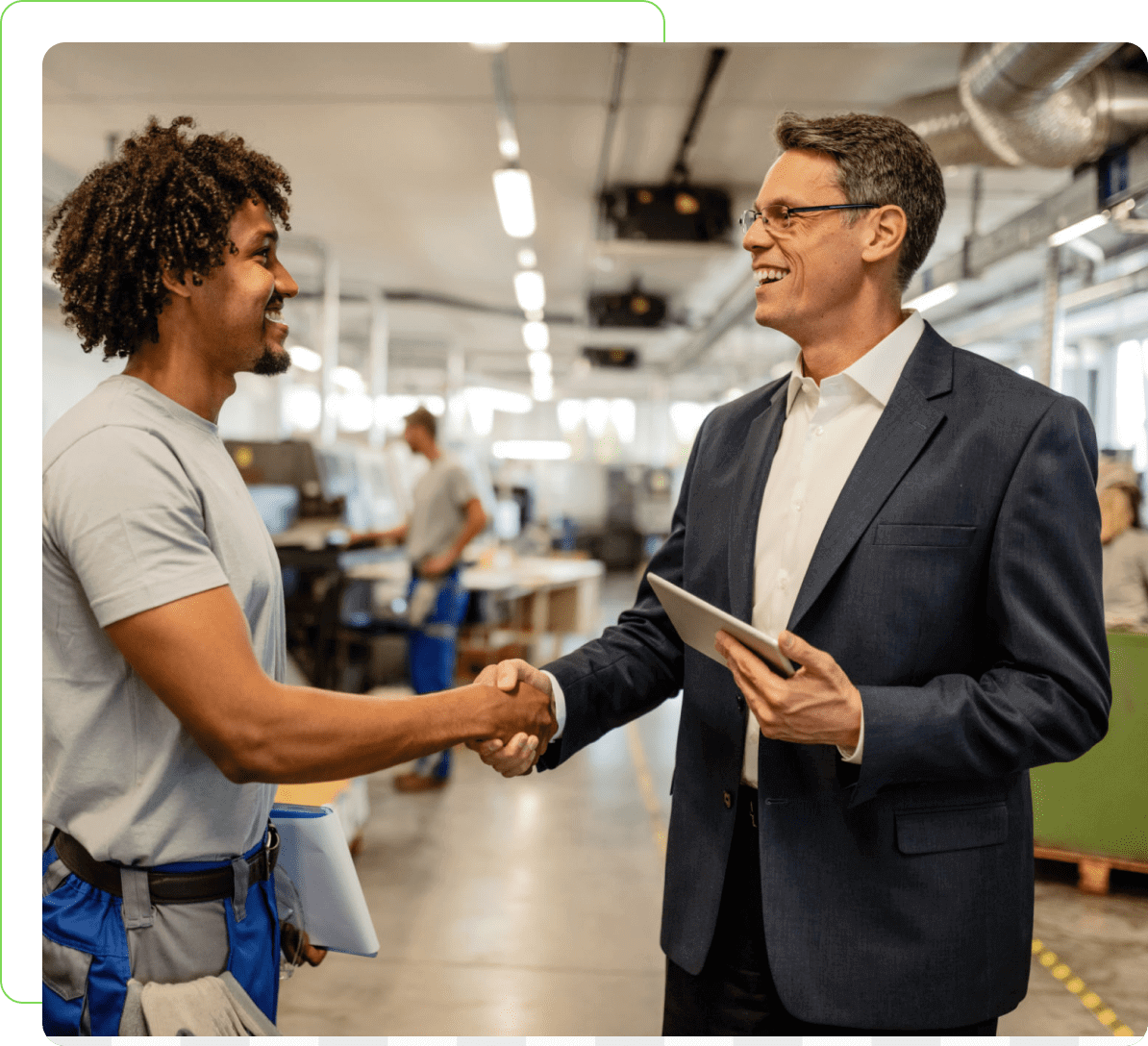 Factory worker and manager shaking hands.