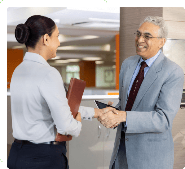 Two people shaking hands in an office.
