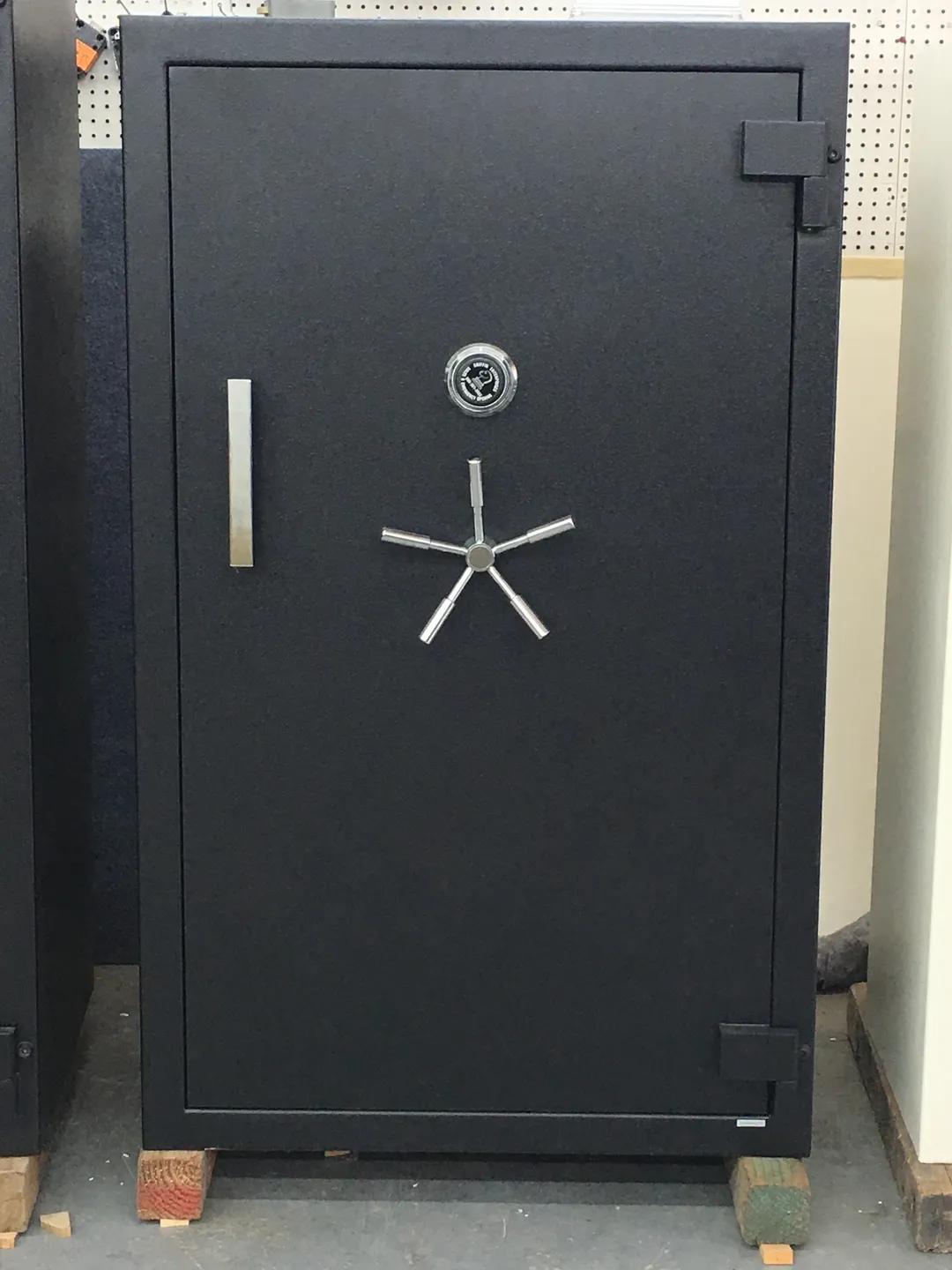 A large black safe with a combination lock and handle.